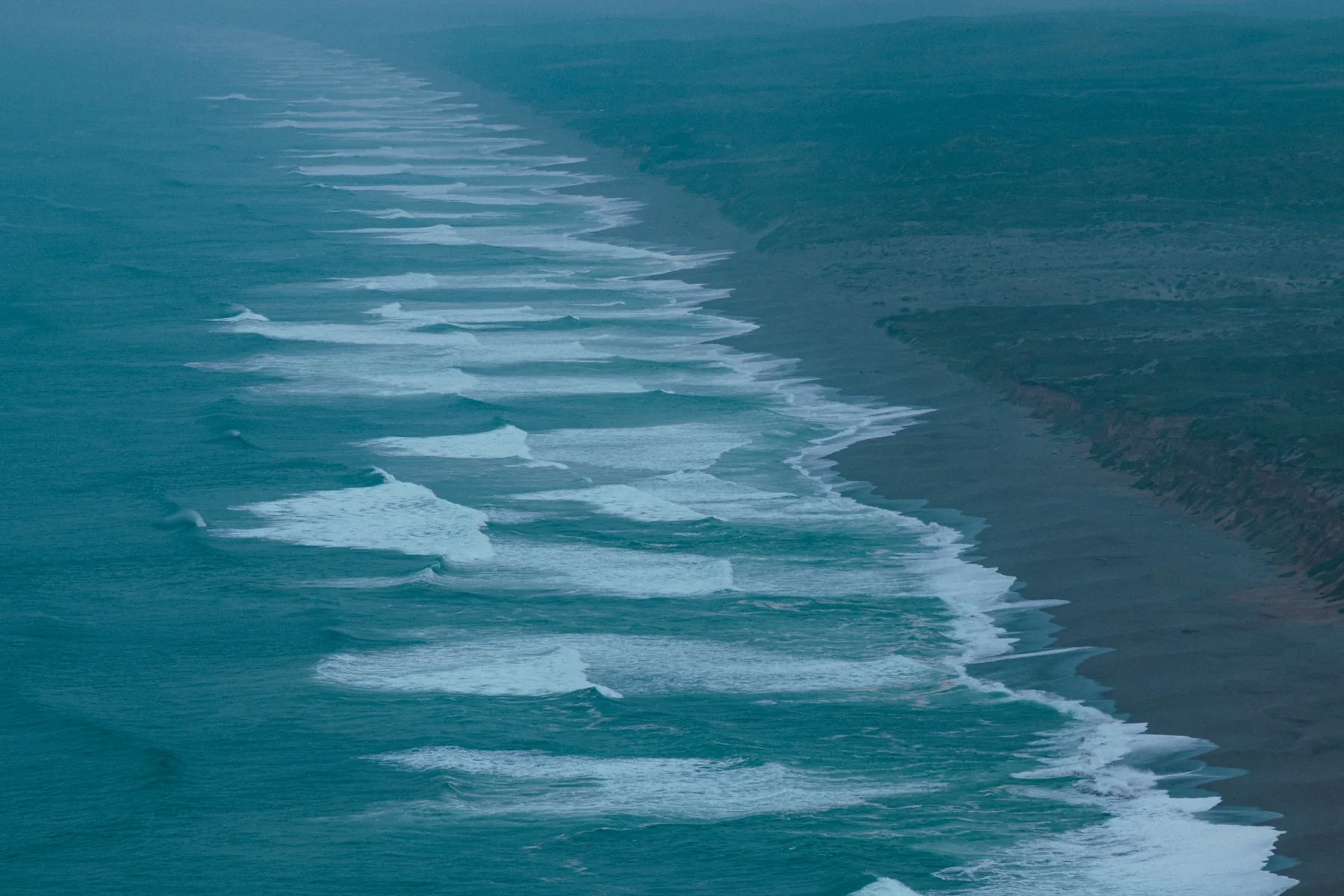 Aerial view of waves tracing a long coastline