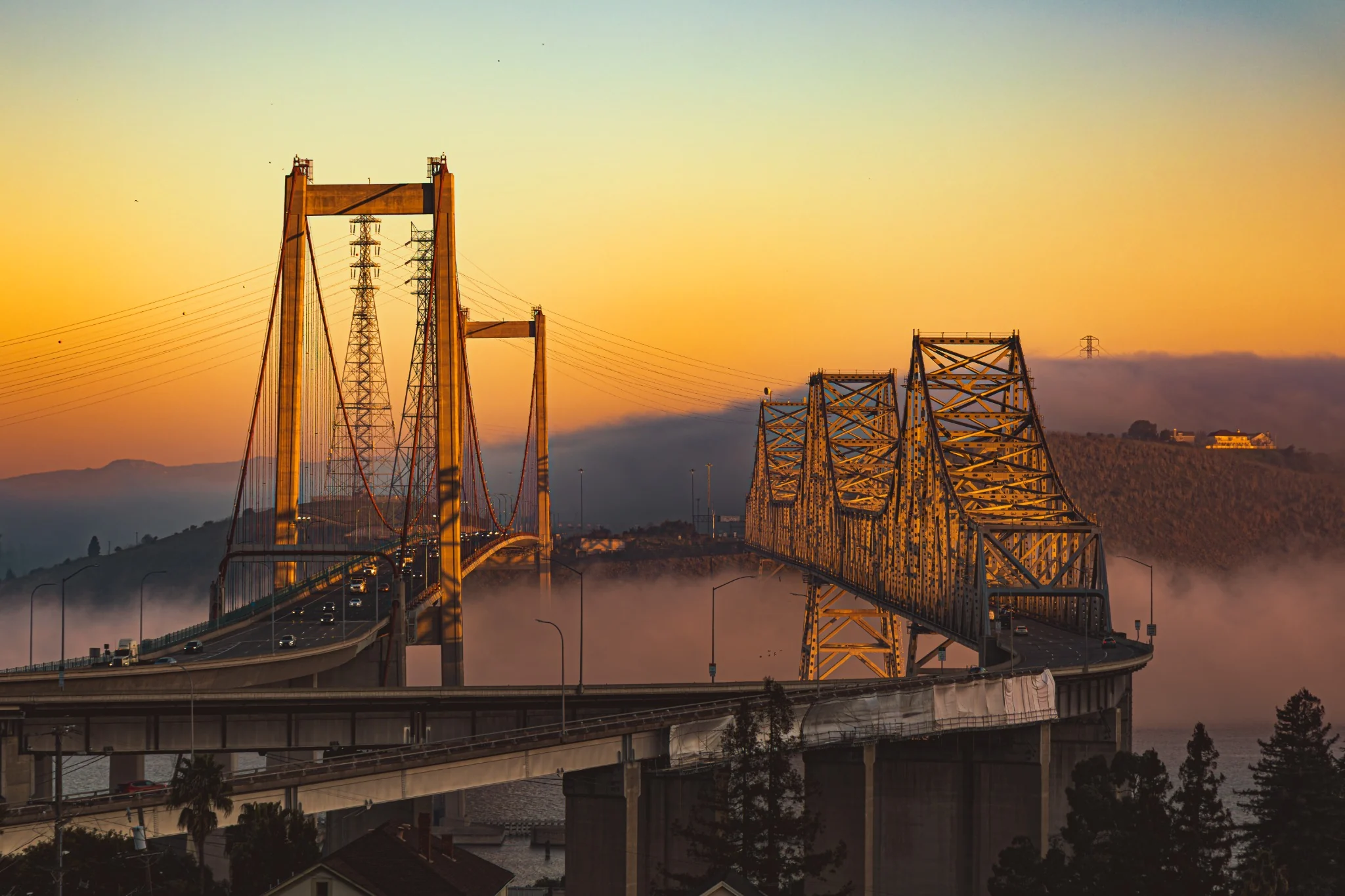 The Carquinez Bridge glowing through dense morning fog and warm early light