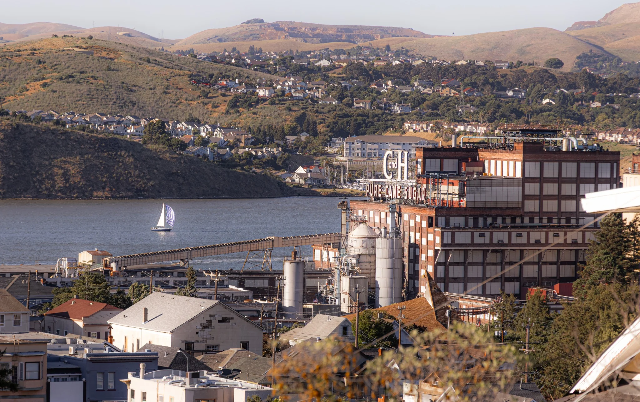 Historic sugar factory beside the water and surrounding hills
