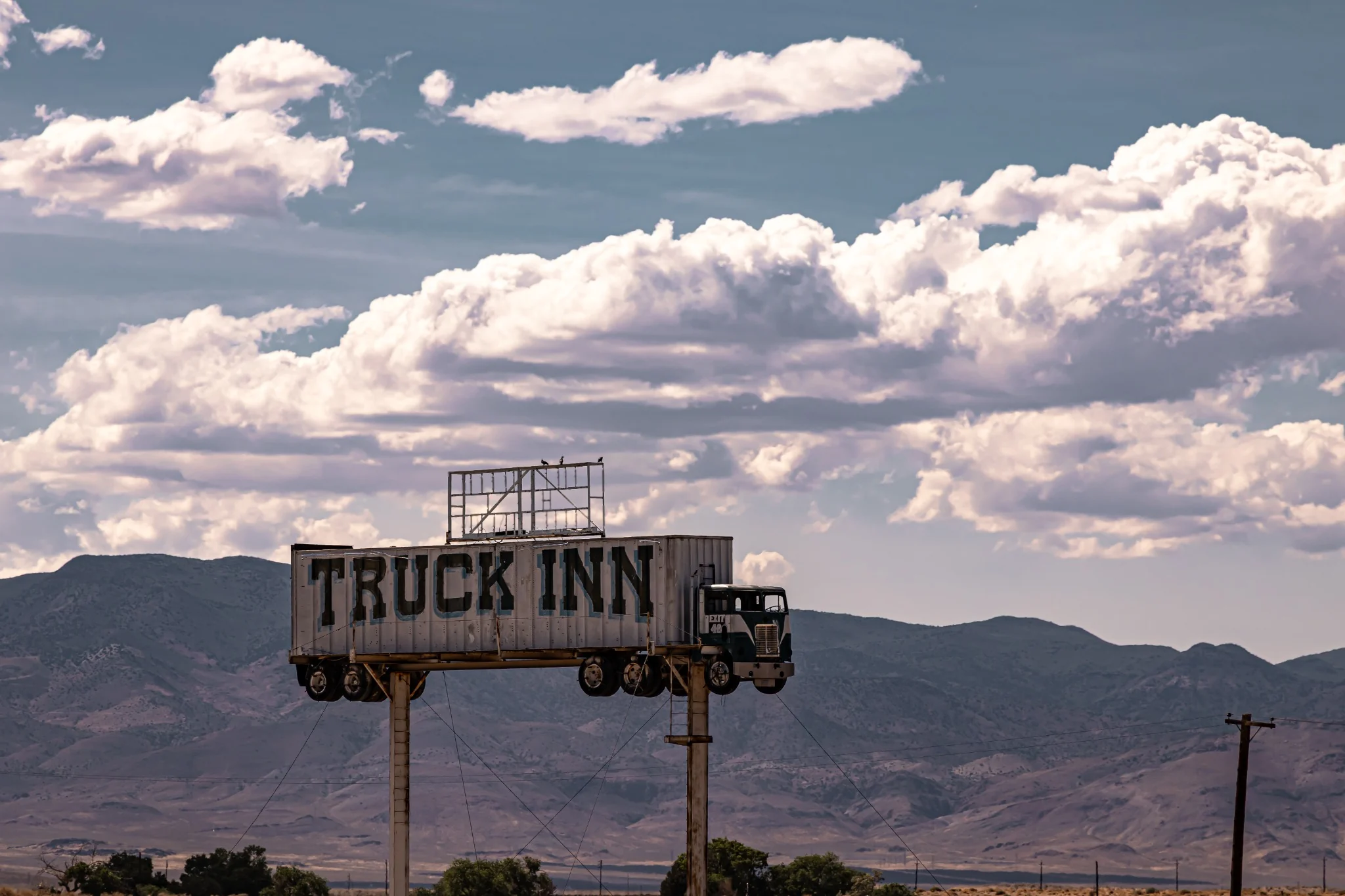 A full-sized semi-truck mounted high above a roadside inn sign in Nevada
